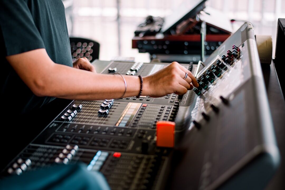 Audio engineer adjusting a sound mixing console during a live broadcast